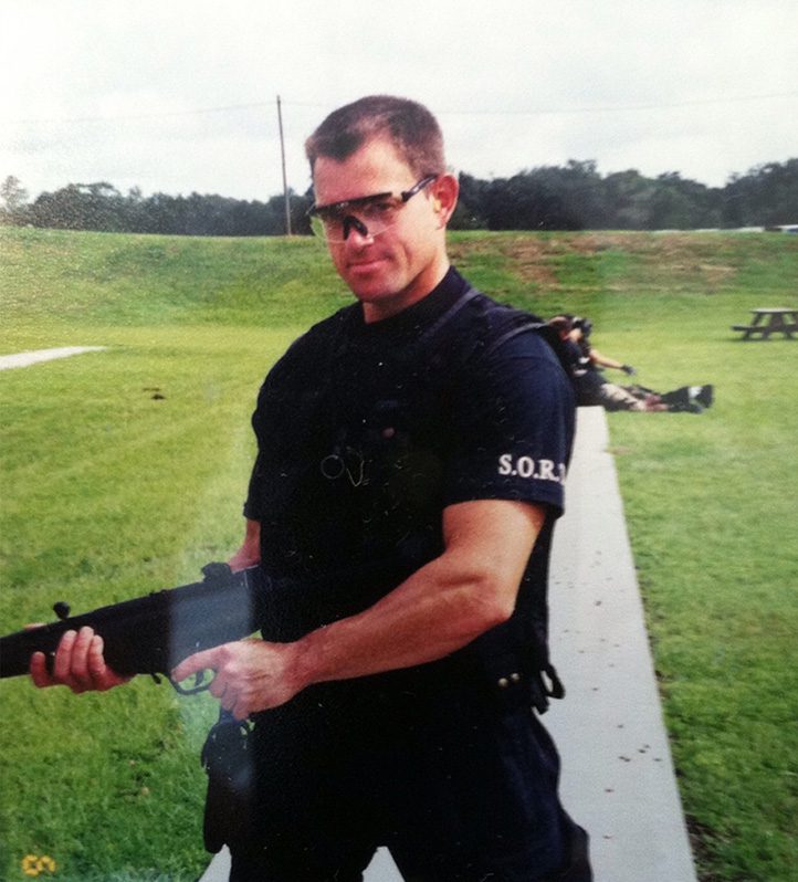 A man in black shirt holding a gun.