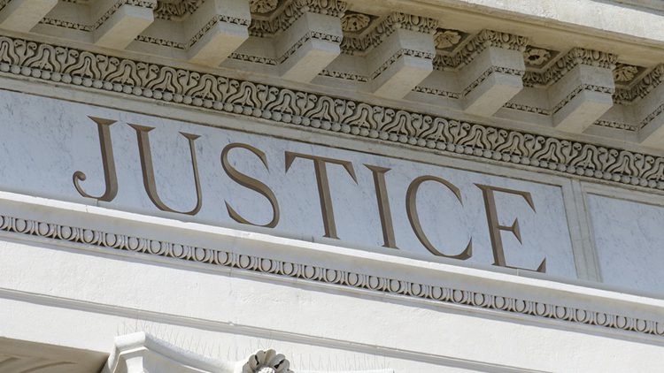 A close up of the word justice on top of a building