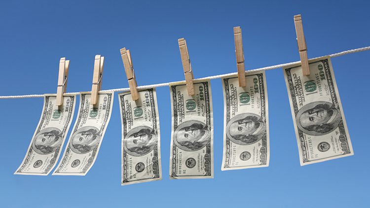 A line of money hanging on a clothes line.